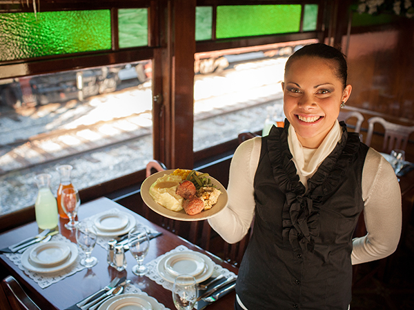 Dine with Strasburg Rail Road One of the servers at the Strasburg Rail Road getting ready to serve a meal aboard the dining car.