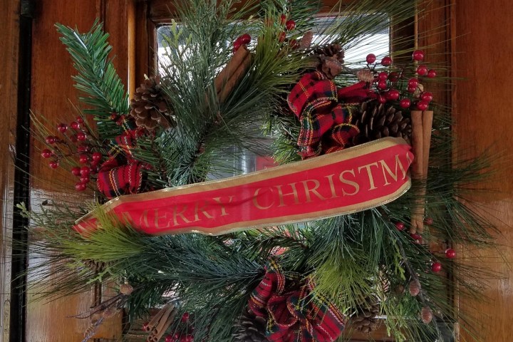 A wreath aboard the door on a Christmas train.