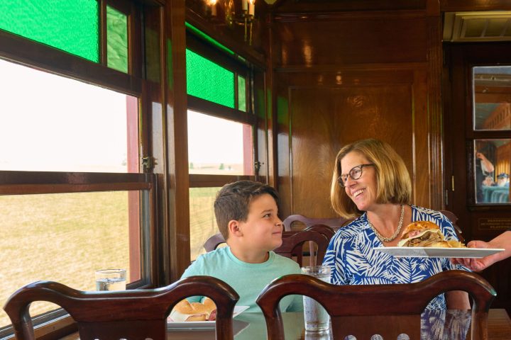 A woman and her son being served a meal on the Strasburg Rail Road dining car.