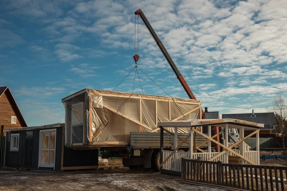 A train being moved with a large crane.