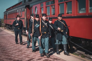 a group of people standing next to a train