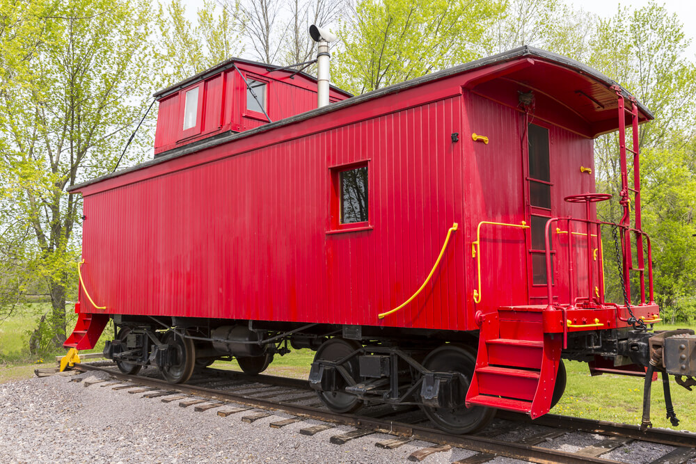 Classic fire-engine red cupola caboose parked on a track.