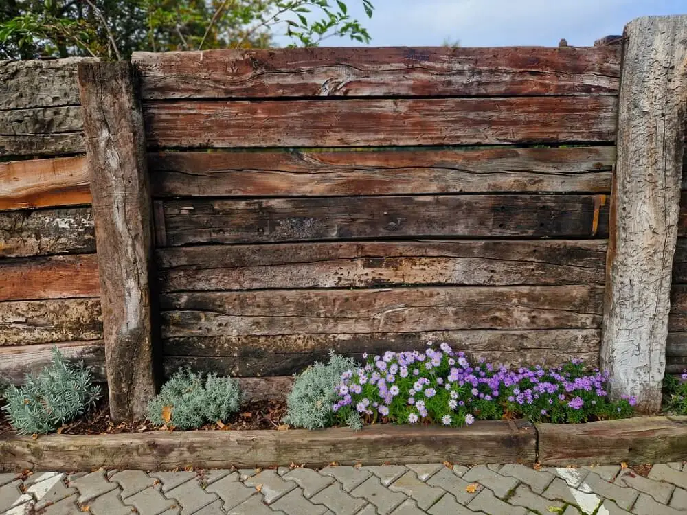 A garden wall made of repurposed railroad ties.